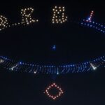 Drone light show forming patterns in the night sky.